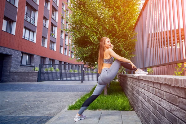 年轻女子体操运动员身材苗条 在一个温暖的夏日 在城市街道上伸展运动 在开阔的空气中伸展 — 图库照片