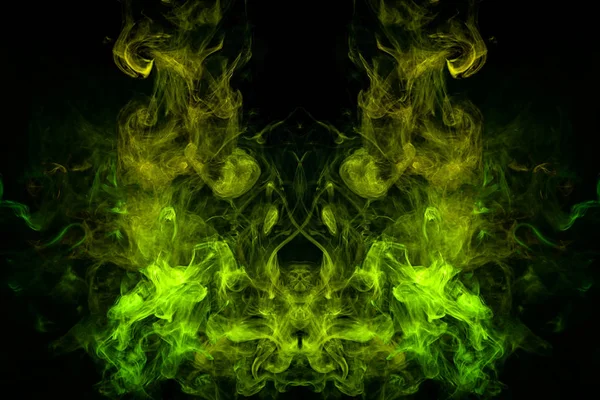 Mocap for cool t-shirts. Dense multicolored smoke of   yellow and green  colors in the form of a skull, monster, dragon  on a black isolated background.