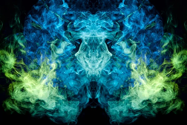 Fantasy print for clothes: t-shirts, sweatshirts. Thick colorful smoke of green, blue colors smoke in the form of a skull, monster, dragon on a black isolated background. Background from the smoke of vap