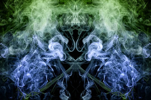 Fantasy print for clothes: t-shirts, sweatshirts.  Colorful green and blue smoke in the form of a skull, monster, dragon on a black isolated background. Background from the smoke of vap