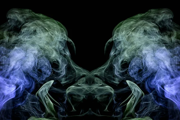 Fantasy print for clothes: t-shirts, sweatshirts.  Colorful green and blue smoke in the form of a skull, monster, dragon on a black isolated background. Background from the smoke of vap