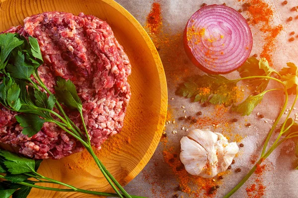 The process of cooking meatballs, hamburger, lasagna and other meat dish. A set of fresh ingredients  for cooking ground beef:beef meat, onion, garlic, spices, salt, pepper.