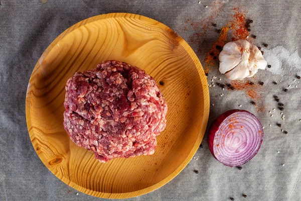 The process of cooking meatballs, hamburger, lasagna and other meat dish. A set of fresh ingredients  for cooking ground beef:beef meat, onion, garlic, spices, salt, pepper.