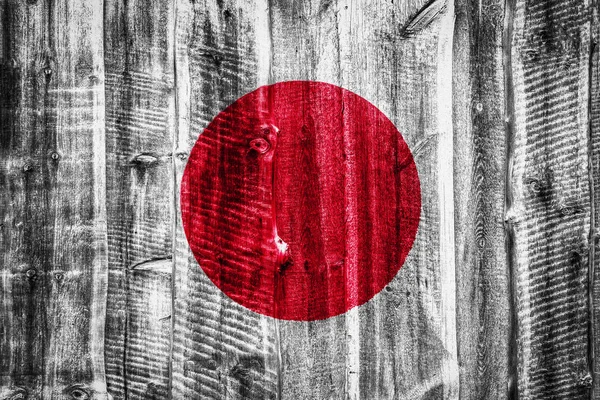 National flag of Japan on a textured wooden background, fence or wall
