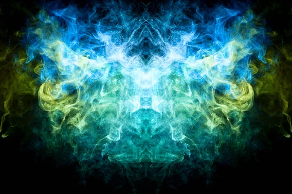 Fantasy print for clothes: t-shirts, sweatshirts.  Colorful blue, green and yellow smoke in the form of a skull, monster, dragon on a black isolated background. Background from the smoke of vap