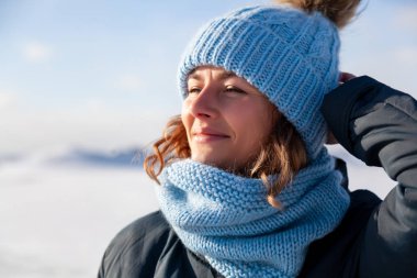 Moda yaşam tarzı sıcak şık giysiler giymiş genç moda kadın portresi kış ve kışın gülümseyen tadını çıkarın. arka plan beyaz kar ve buz dağları neşeli kadın portresi