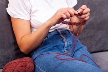 T-shirt örgü iğneleri doğal bir yün üzerinden güzel bir kadında Close-up konu kahverengi şapka, bir kadın doğru örgü gösterilmiştir