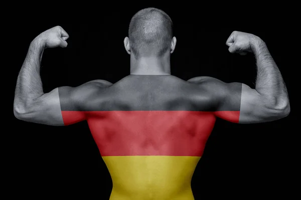 一名年轻的体育男子的背部穿着一件印有德国国旗的 背景是黑色的孤立的 民族自豪感与爱国主义的概念 — 图库照片