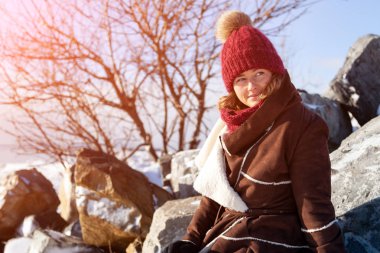 Şapkalı, uzun saçlı Genç güzel kadın portresi açık yakın poz om kış taş kat. Yeniyıl, kış kavram yürümeye. 