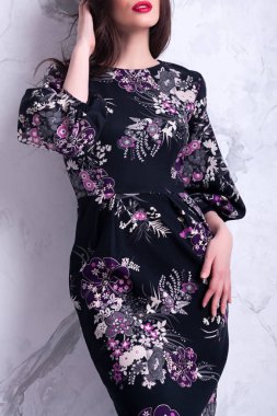 Şehvetli güzel brunnete kadın siyah çiçekli elbiseyle poz. Uzun kıvırcık saçlı kız. Mutlu kadın kutlamak tatil