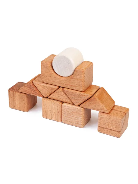 Photo wooden constructor of small cubes, triangles, balls and other forms of beech on a white isolated background. Wooden designer, built in the shape of the castle