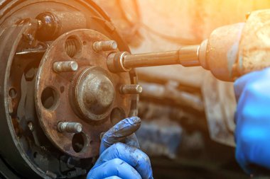 Yakın çekim değişimi eski ön fren disk, fren Kaliper ve hub fındık üzerinde bir araba bir Asansör içinde bir araba tamir dükkanı Pnömatik bir anahtar ile ortaya çıkar. Oto mekanik tamir.