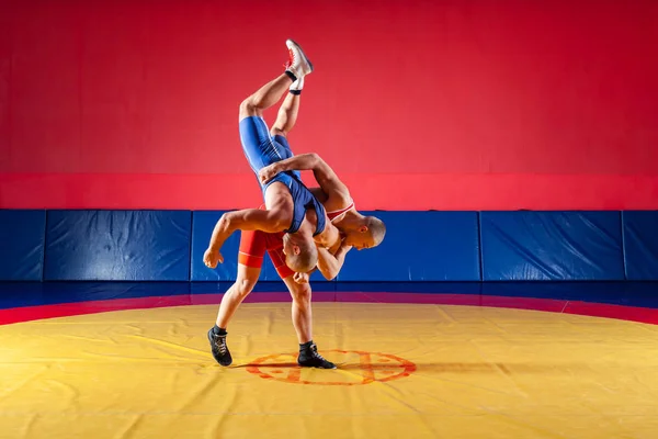 파란색과 빨간색 레슬링 스타킹에 Wrestlng 체육관에서 카펫을 레슬링 노란색에 엉덩이 — 스톡 사진