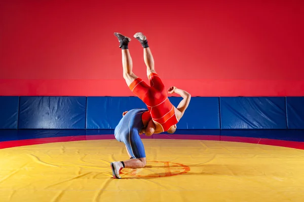 公正なレスリングのコンセプトです 青と赤のタイツをレスリングで つの若い男性が Wrestlng と黄色のカーペットをジムでプロレスのレスリング スープレックス — ストック写真