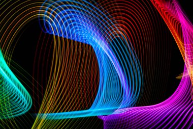 Neon renkler yeşil, kırmızı, mavi, sarı ve pembe sarmal çizgiler. Arka plan mavi neon ışık şekilleri parlayan. Poster, Web sitesi, broşür, yazdırma için parlak çizgiler.