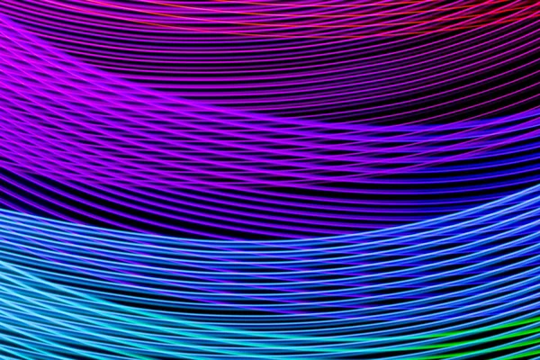 Abstract rainbow neon glowing crossing lines pattern. Dark  background of colorful neon glowing light shapes.