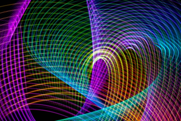 Abstract rainbow neon glowing crossing lines pattern. Dark  background of colorful neon glowing light shapes.