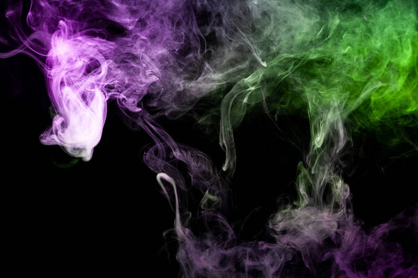 Thick pink and green smoke on a black isolated background. Background from the smoke of vap