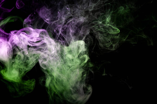 Thick green and purple smoke on a black isolated background. Background from the smoke of vap