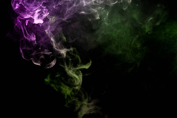 Thick pink and green smoke on a black isolated background. Background from the smoke of vap