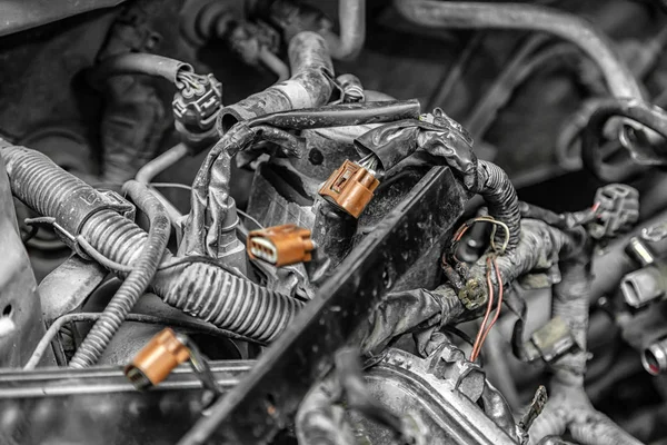 Close-up of the wiring of the engine of a supported car