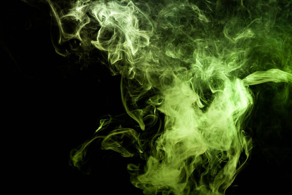 Dense multicolored smoke of green colors on a black isolated background. Background of smoke vape
