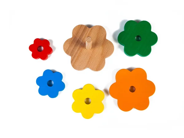 照片上的木制玩具儿童的分选金字塔的五颜六色的部分在花的形状上的白色隔离的背景 精细运动儿童发育的玩具 — 图库照片