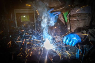 Adam Kaynakçı Kaynak maskesi, düzgün ve mavi koruyucu eldiven inşaat metal araba susturucu ile kaynak makinesi arka plan inşaat alanında otomatik onarım dükkanda kaynak