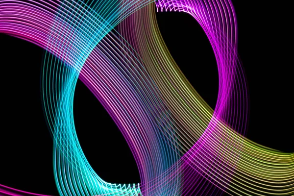 Abstract light blue, pink and yellow trails in random motion background image.Striped Neon Lights in Rainbow Colors