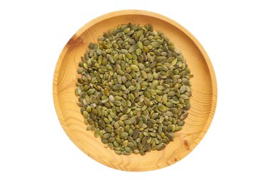 Soyulmuş Kabak çekirdeği bir ahşap çam plaka beyaz izole zemin üzerinde. Kase kabak çekirdeği fındık, üstten görünüm satır. Soyulmuş Kabak çekirdeği desen