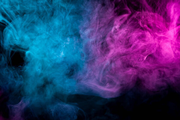 Fog colored with bright pink and blue gel on dark background