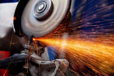 Yakın çekim A güçlü adam Kaynakçı Kaynak Makine atölyesinde, turuncu kıvılcım sinek taraf için araçlar arka planda bir metal araba parçası kaynak