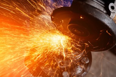 Bir genç adam kaynakçı taşlama atölye bir açı değirmeni metal, sinek tarafa kıvılcım