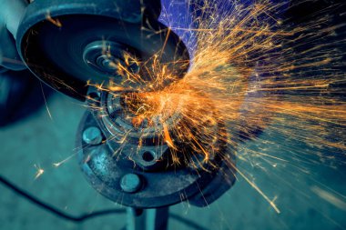 Metal El Daire testere ile parlak yanıp söner bir oto tamircisi için arka plan araçları farklı yönlerde uçan testere bir adam Close-up. Otomatik mekanik çalışmalarını.