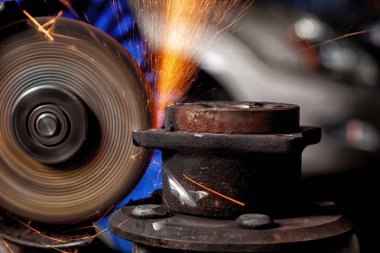 Metal El Daire testere ile parlak yanıp söner bir oto tamircisi için arka plan araçları farklı yönlerde uçan testere bir adam Close-up. Otomatik mekanik çalışmalarını.
