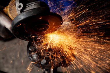 Metal El Daire testere ile parlak yanıp söner bir oto tamircisi için arka plan araçları farklı yönlerde uçan testere bir adam Close-up. Otomatik mekanik çalışmalarını.