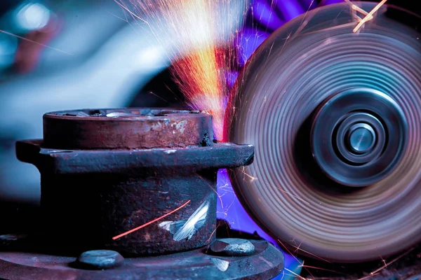 Bir genç adam kaynakçı taşlama atölye bir açı değirmeni metal, sinek tarafa kıvılcım