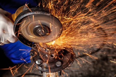 Metal El Daire testere ile parlak yanıp söner bir oto tamircisi için arka plan araçları farklı yönlerde uçan testere bir adam Close-up. Otomatik mekanik çalışmalarını.