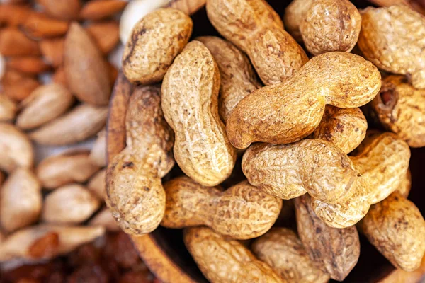 Cacahuetes Sin Pelar Una Placa Cedro Madera Fondo Una Dispersión — Foto de Stock