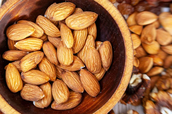 Las Almendras Peladas Una Placa Cedro Madera Fondo Una Dispersión — Foto de Stock