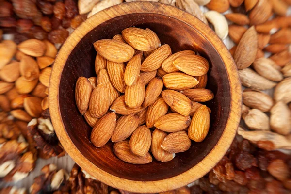 Las Almendras Peladas Una Placa Cedro Madera Fondo Una Dispersión — Foto de Stock