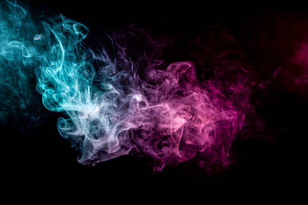 Close up swirling pink and blue smoke on black isolated background
