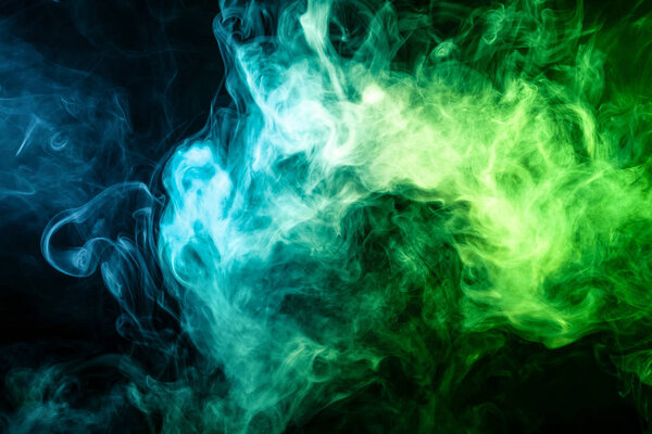 Thick blue and green smoke on a black isolated background. Background from the smoke of vap
