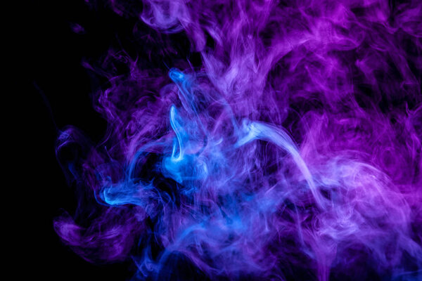 Frozen abstract movement of explosion smoke multiple purple and blue colors on black background. Background from the smoke of vap