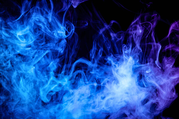 Dense blue and purple smoke on a black isolated background. Background of smoke vap