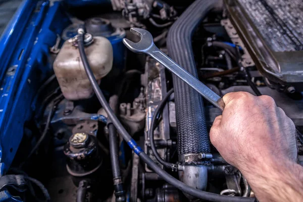 Close Van Een Jonge Auto Reparateur Holding Een Moersleutel Zijn — Stockfoto