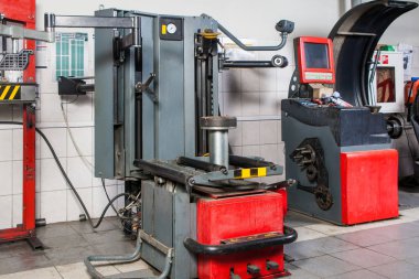 Araba tamir ve lastik montaj için bir atölye arka planda bir elektronik kontrol sistemi ile modern lastik değiştiricisinin yakın duruyor. Eski yerine koymak ve araba lastikleri Dengeleme için aygıtlar