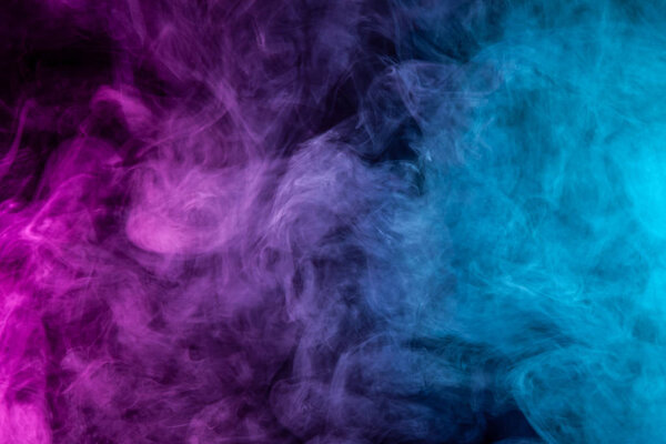 Frozen abstract movement of explosion pink and blue smoke multiple colors on black background. Background from the smoke of vap