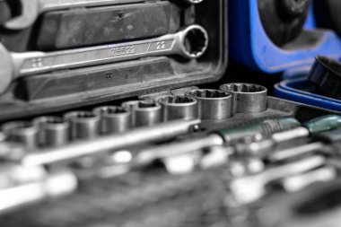 Düz yatıyordu metal aletleri: yuvalı eğri somun anahtarları, ratchet, değiştirilebilir kafaları farklı boyut ve diğer araçlar kümesi vardır araç kutusunda, üstten görünüm. Yakın çekim Carpenter'ın alet çantası