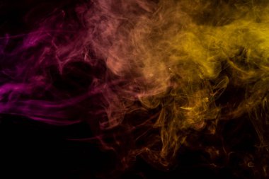 Donmuş soyut hareket patlama sarı ve pembe siyah arka plan üzerine çok sayıda renk duman. Arka plandan vape duman